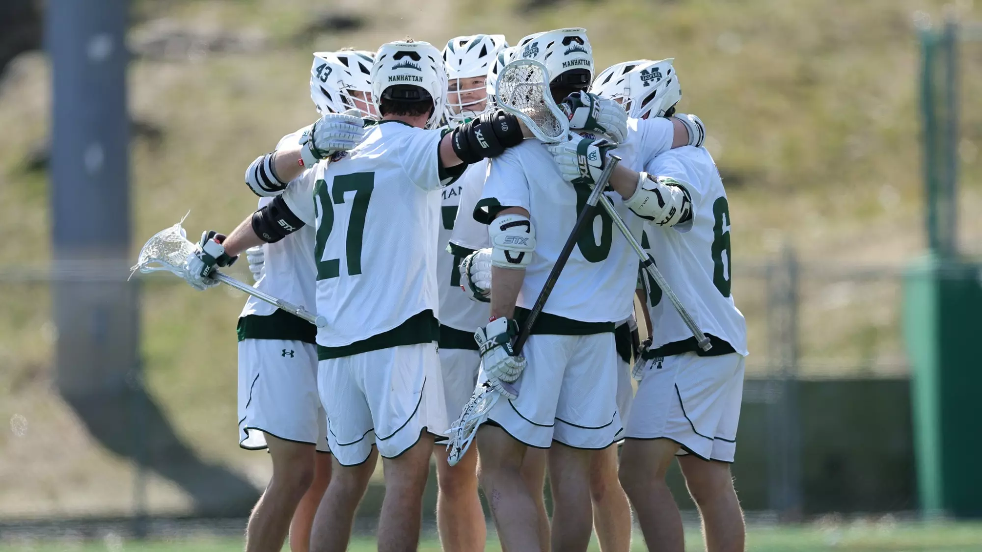 Men's lacrosse huddle after a goal